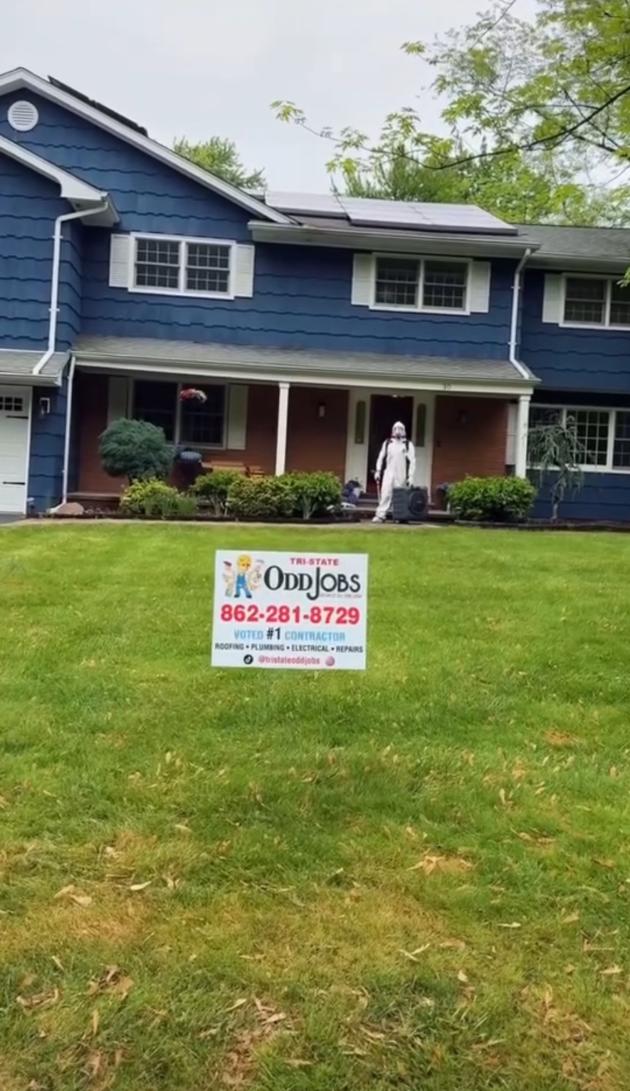 Tri-State Odd Jobs team at a blue house with the company sign on the front lawn